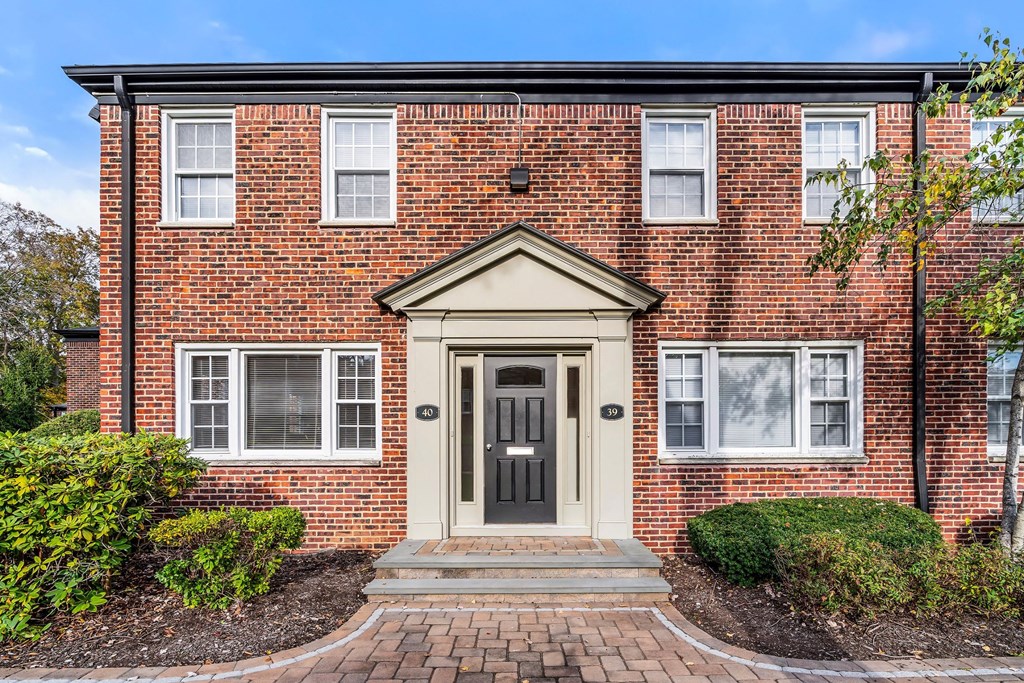 the front of a brick house with a black door