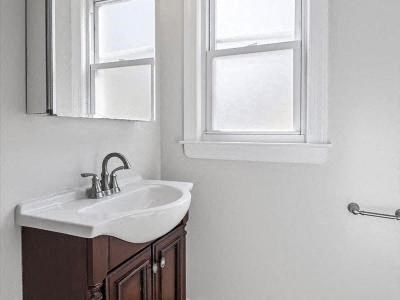 a bathroom with a sink and a mirror and a window