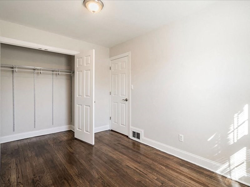 an empty bedroom with a closet and a door to the bathroom