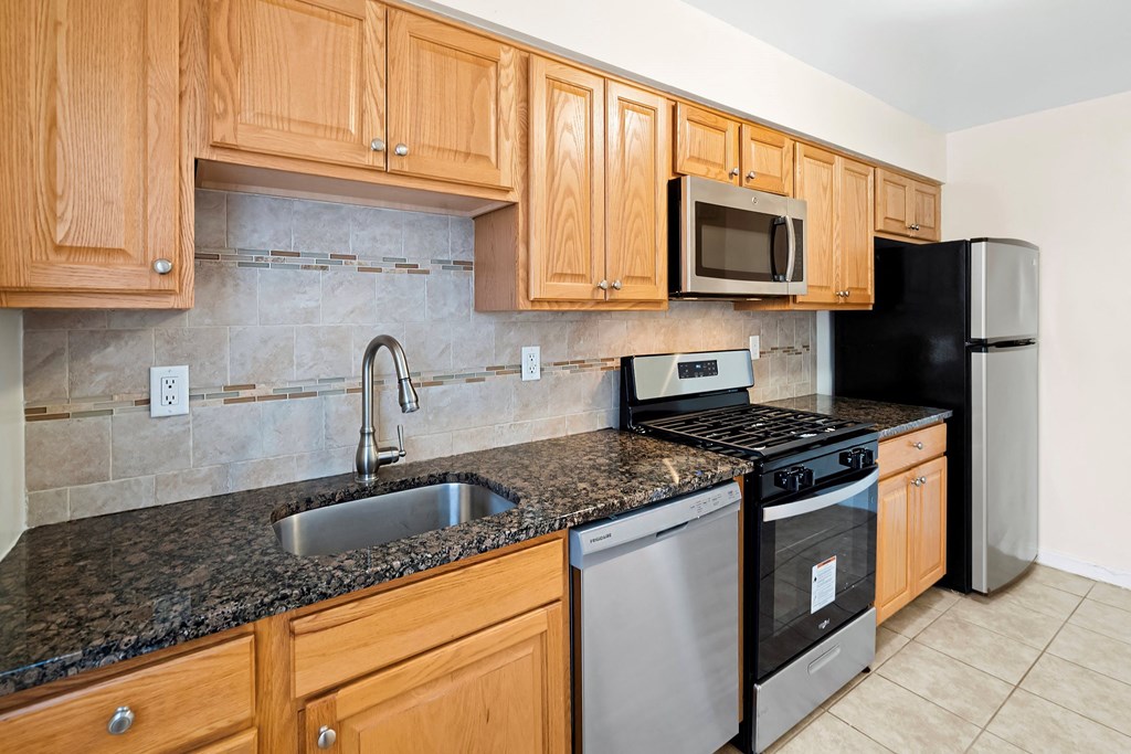 a kitchen with granite counter tops and wooden cabinets