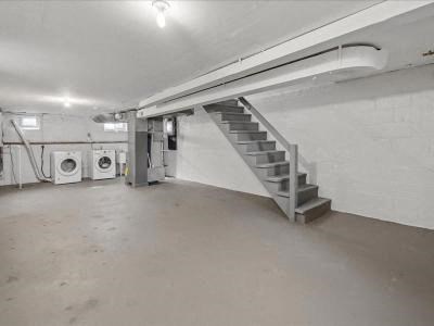 an empty garage with a staircase and washing machines