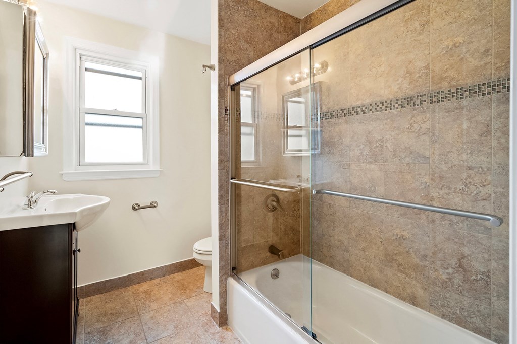 a bathroom with a shower and a sink and a toilet