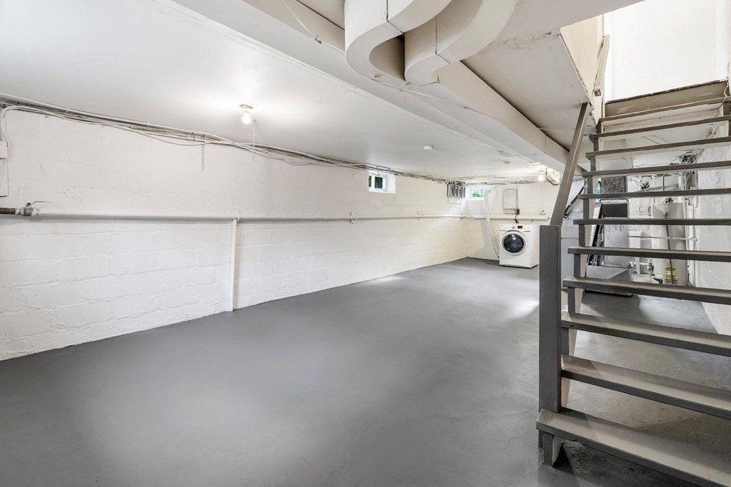 the interior of a parking garage with stairs and a white wall