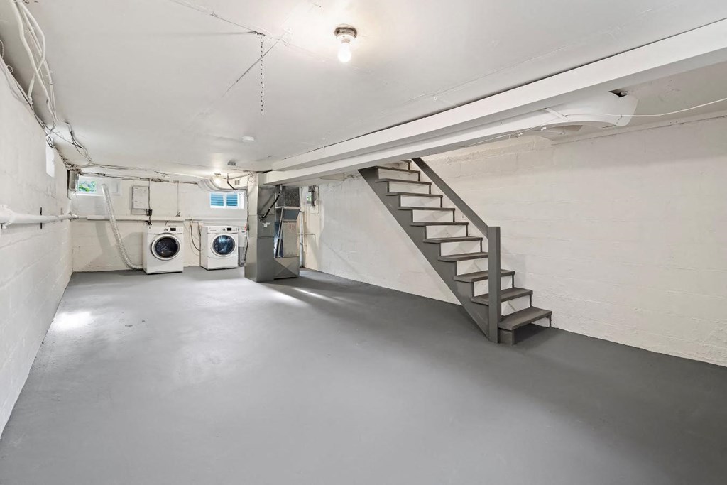 a laundry room with a staircase and a washing machine