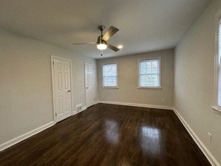 an empty living room with wood floors and a ceiling fan