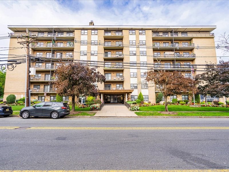 a large apartment building with a car parked in front