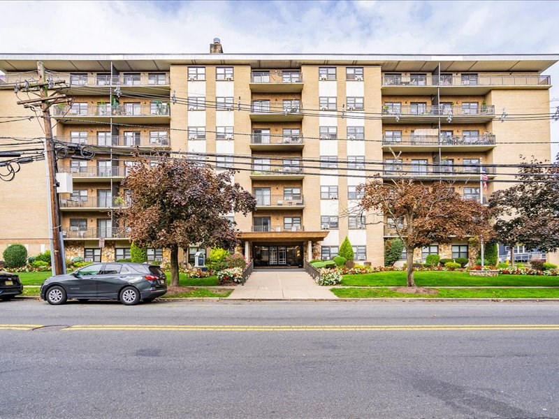 a large apartment building with a car parked in front
