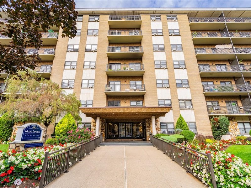 the entrance to a large apartment building with a sidewalk in front of it