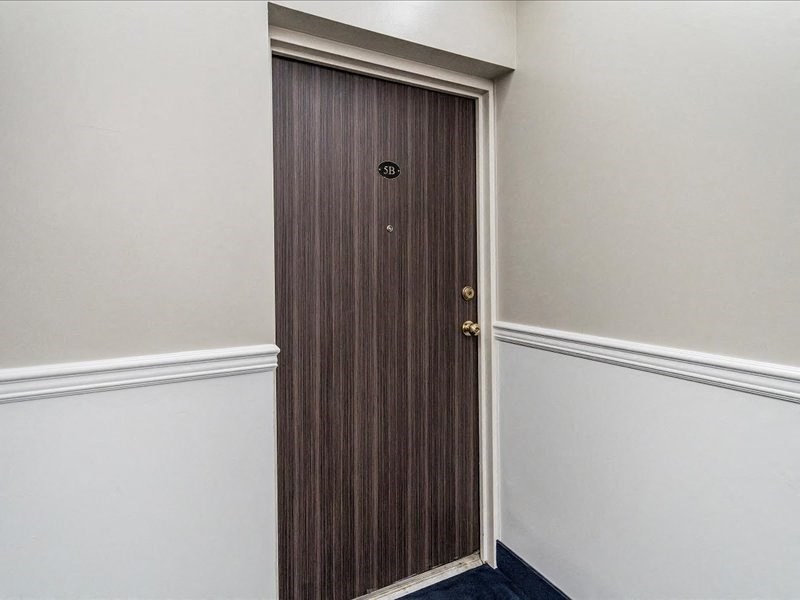 a wooden door in a room with a white wall