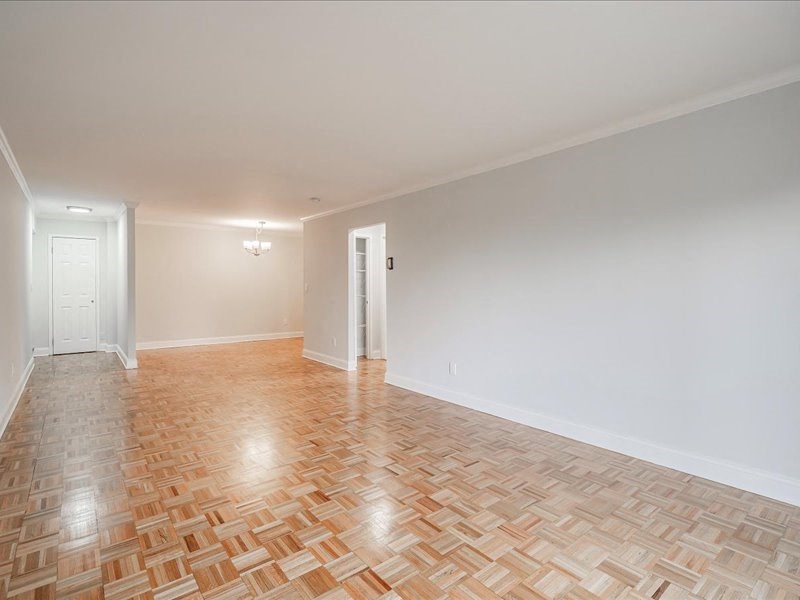 an empty living room with a wooden floor