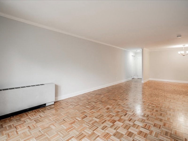 an empty living room with a wooden floor and white walls