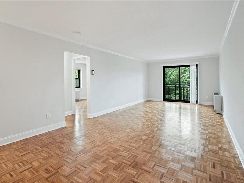 an empty living room with wood flooring and a sliding glass door