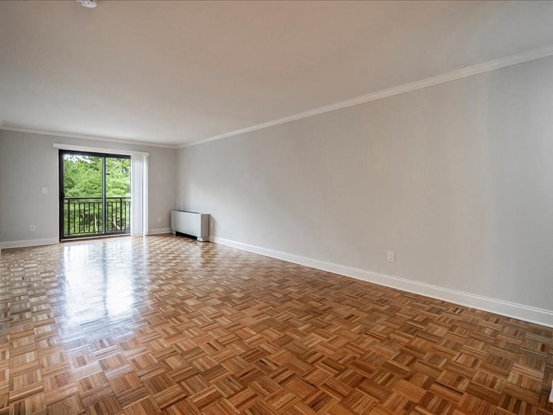 an empty living room with wood flooring and a sliding glass door