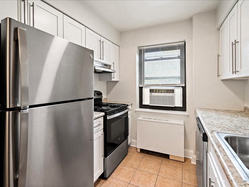 a kitchen with stainless steel appliances and white cabinets