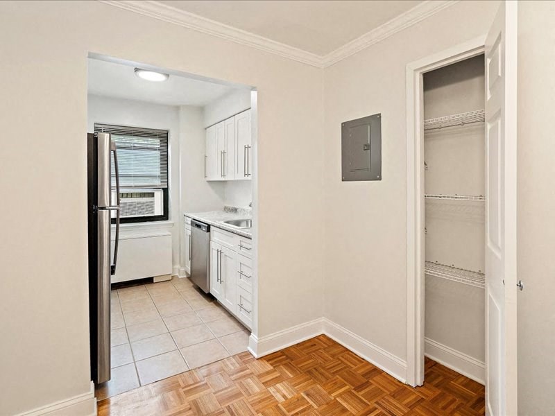 an empty kitchen with a refrigerator and a sink