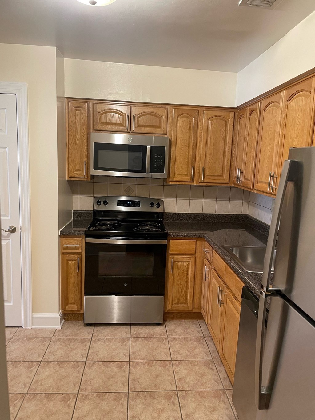 a kitchen with stainless steel appliances and wooden cabinets