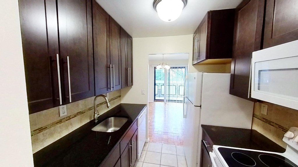 a kitchen with dark wood cabinets and a sink