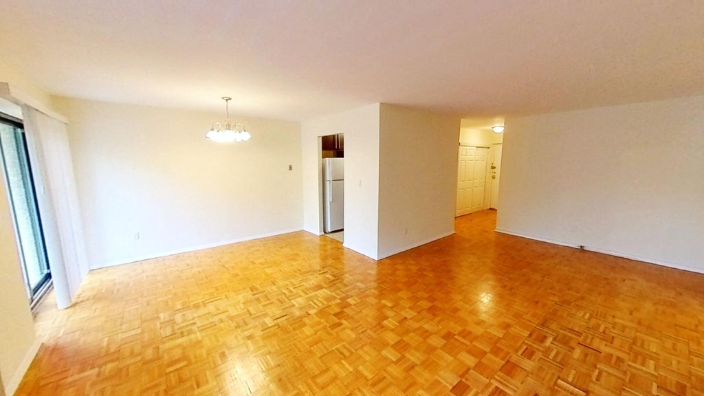 an empty living room with a hard wood floor