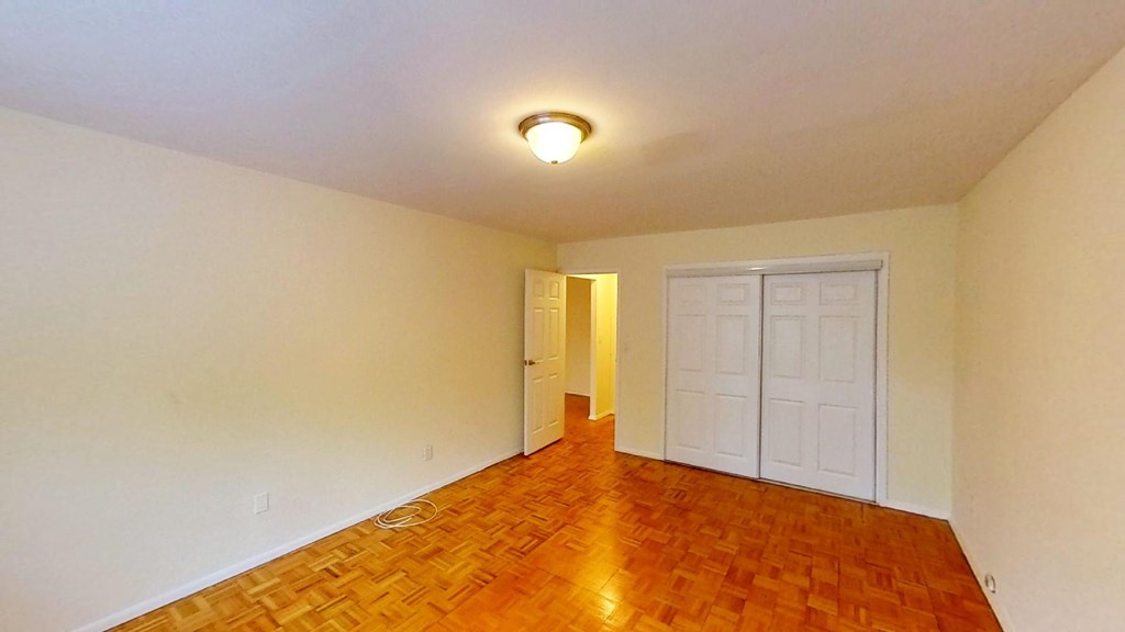 an empty living room with a hard wood floor and a white door