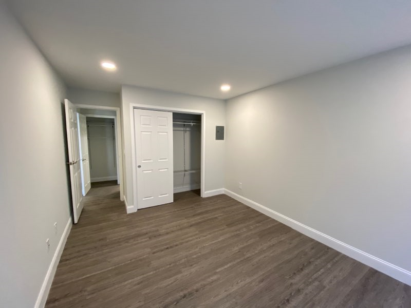 a living room with white walls and a wooden floor