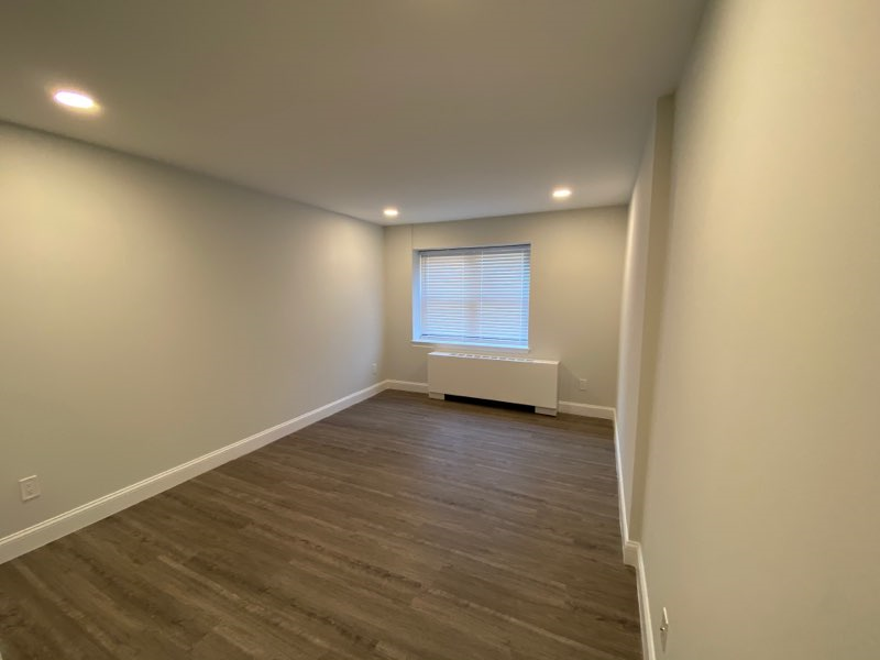 a living room with a window and wooden floors