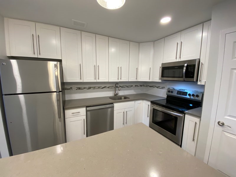 a kitchen with stainless steel appliances and white cabinets