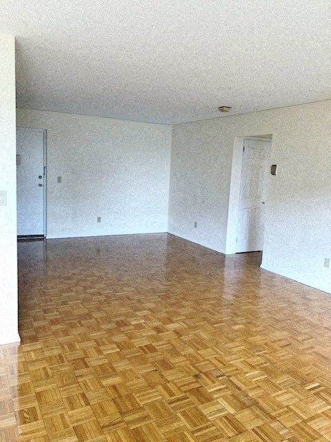 an empty living room with wood floors and white walls