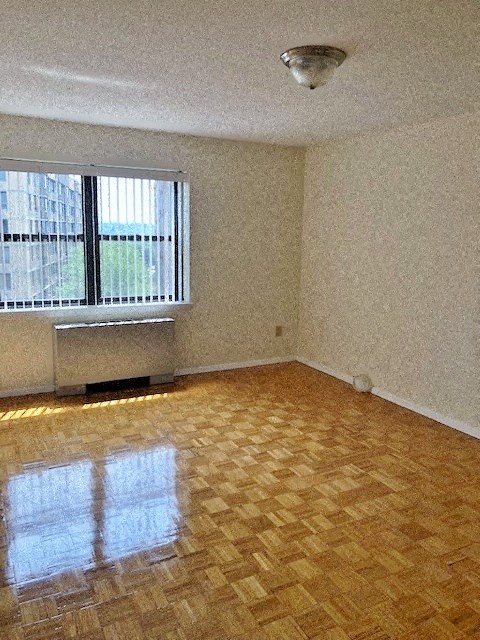 an empty room with a window and wooden floors