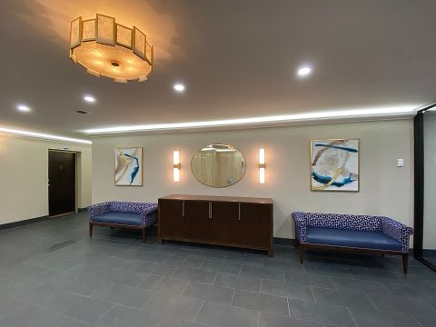 a lobby with two blue chairs and a table