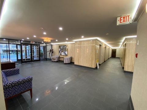 a large room with furniture and a exit sign