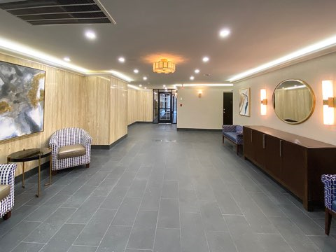 a large hallway with chairs and a mirror