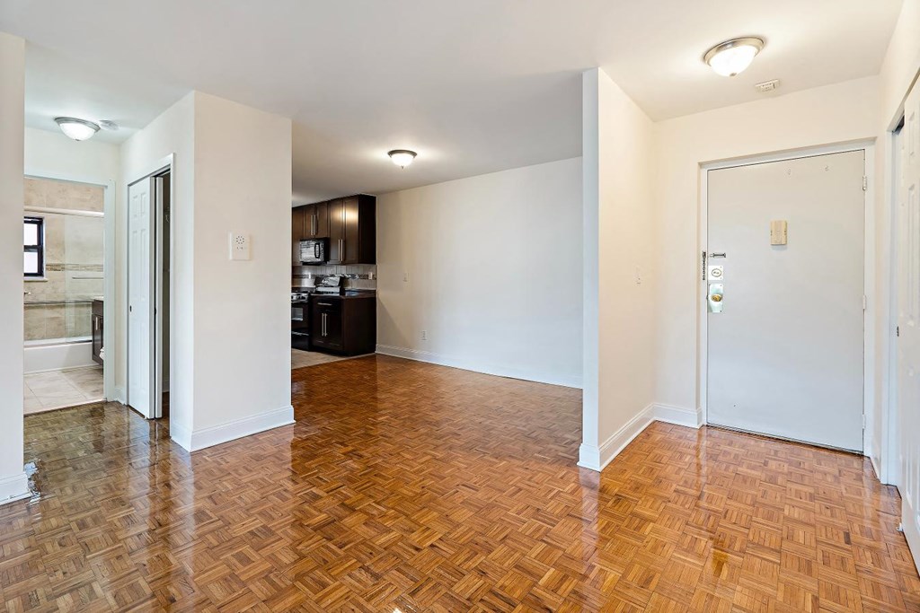 a renovated living room and kitchen with wood flooring