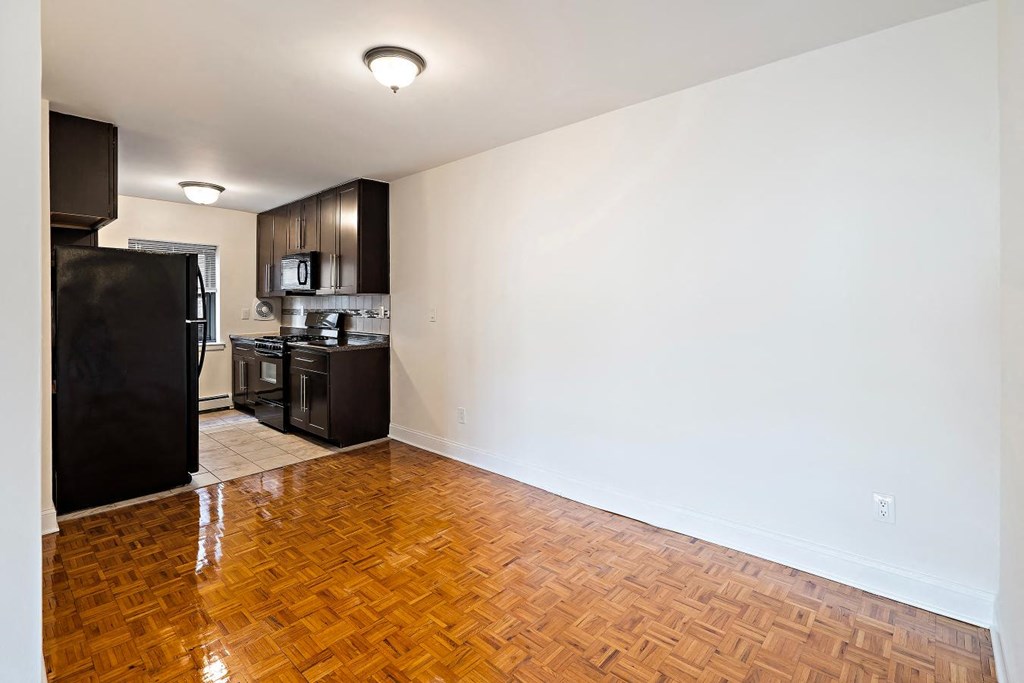 an empty living room and kitchen with a wood floor