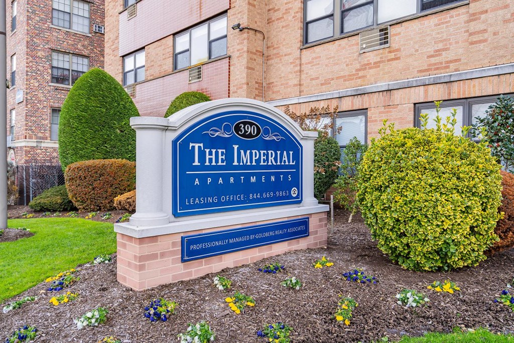 the imperial apartments sign in front of a brick building