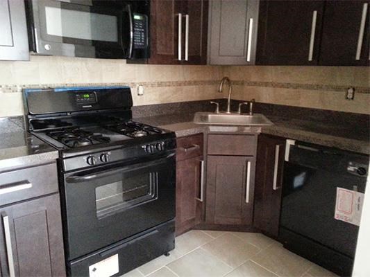 a kitchen with a stove and a sink and a microwave