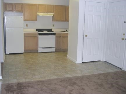 an empty kitchen with a stove and a refrigerator