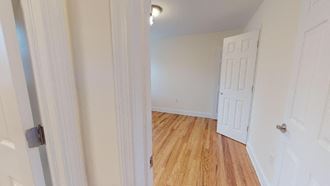 a bedroom with a white door and a wood floor