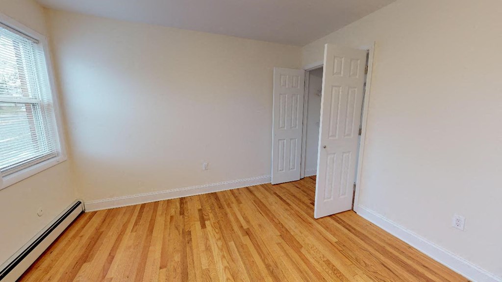 a room with a wooden floor and an open door