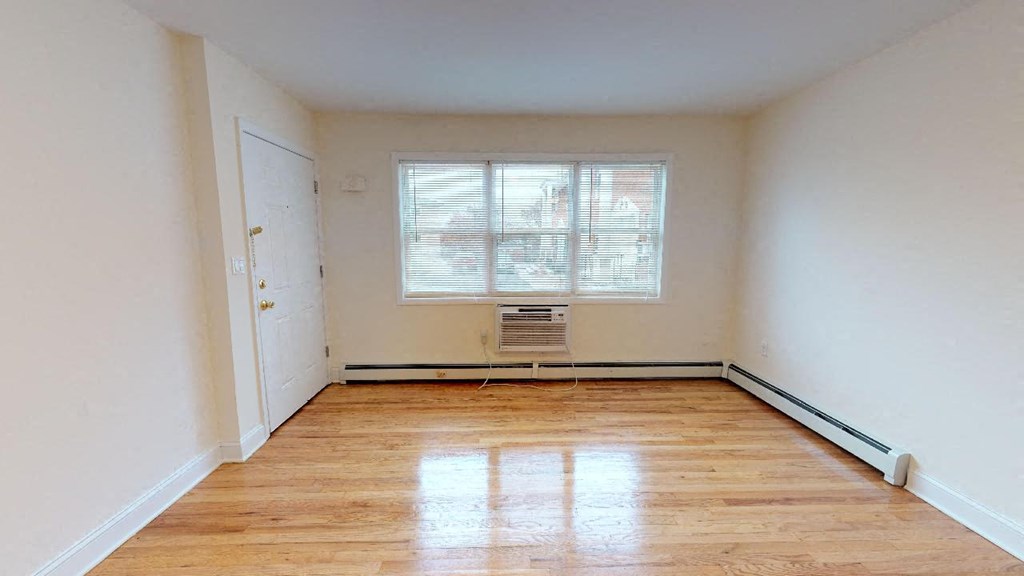 an empty room with a wood floor and a window