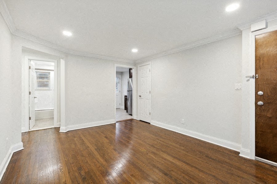 an empty living room with white walls and wood floors