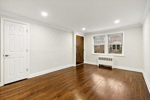 a living room with wood floors and white walls and a white door