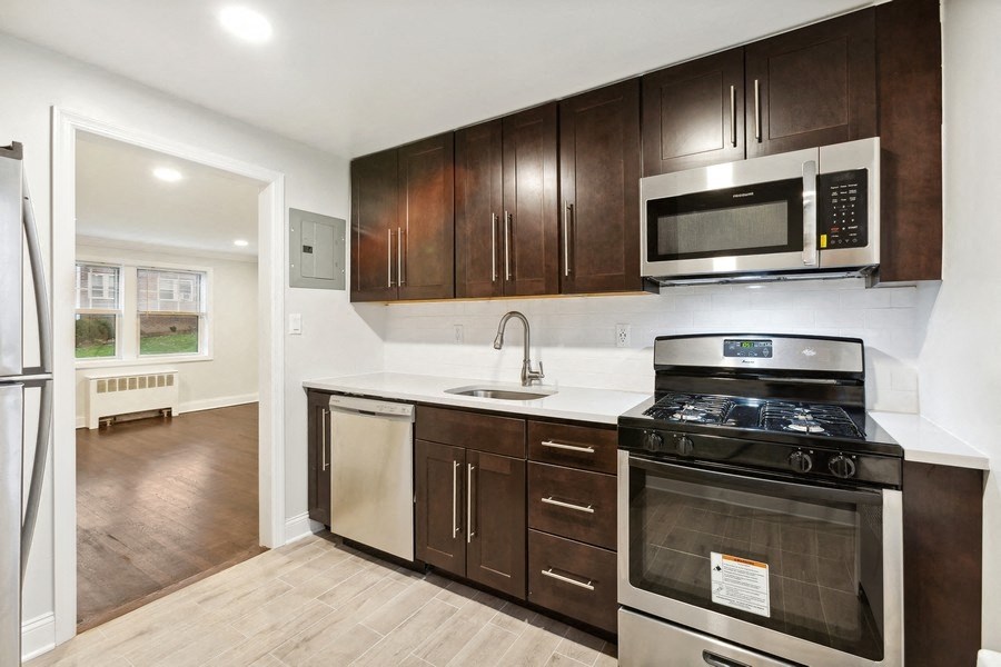 a kitchen with wooden cabinets and a stove and a microwave