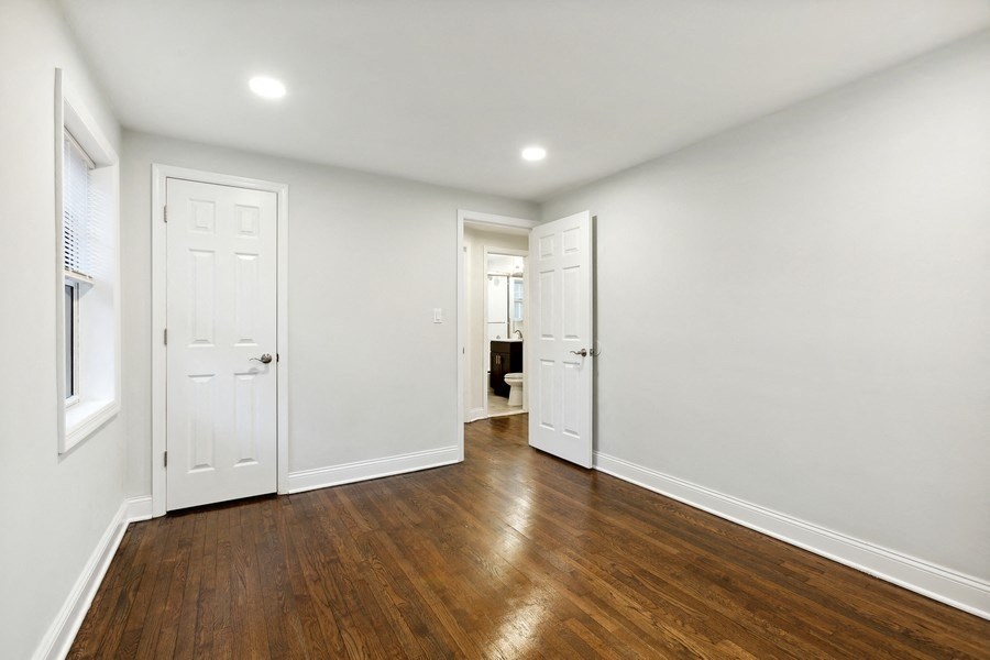 an empty living room with white walls and wood floors