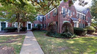a brick house with a sidewalk in front of it