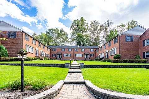 a courtyard with a fountain in front of a brick building