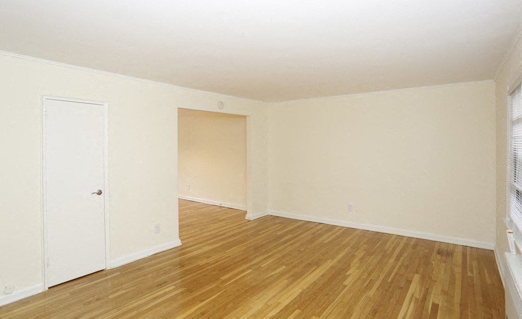 an empty room with a hard wood floor and white walls