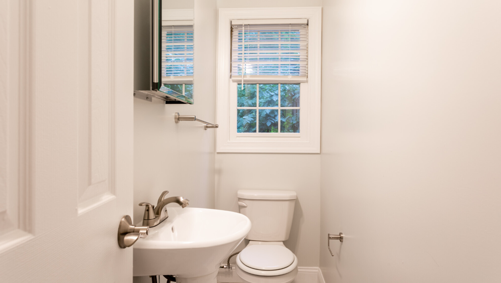 a bathroom with a toilet and a sink and a window