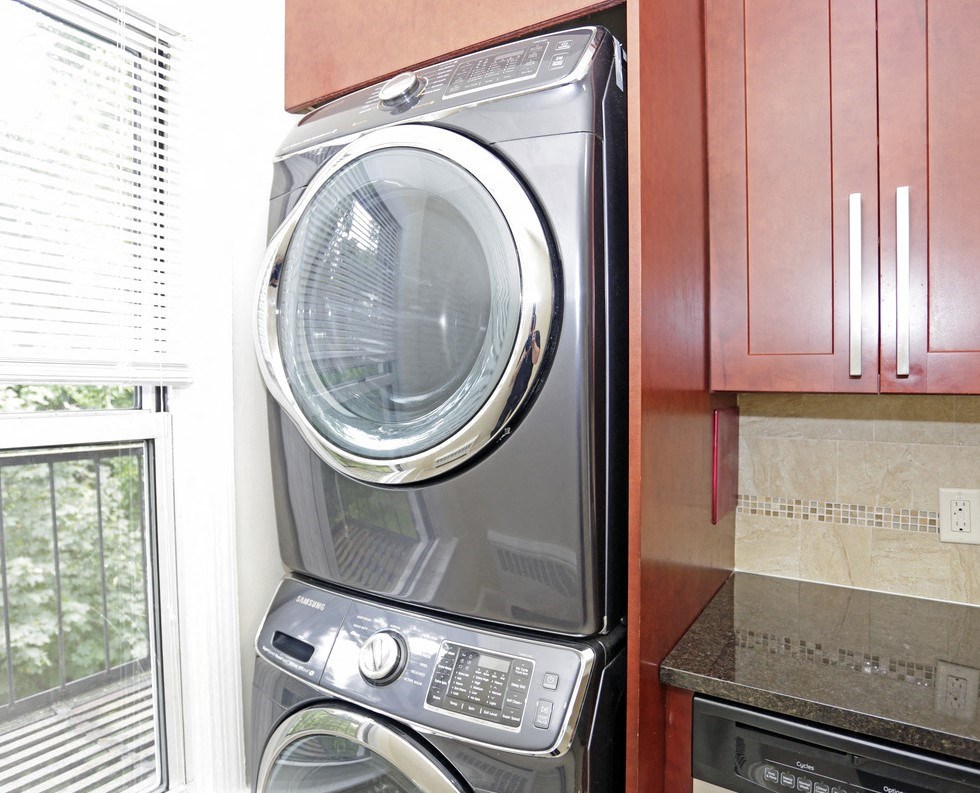 a washer and dryer in a kitchen with brown cabinets