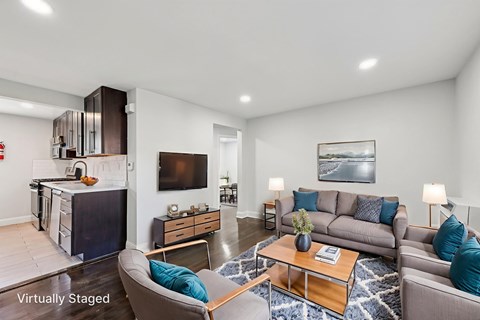 A living room with a grey couch, a coffee table, and a television.