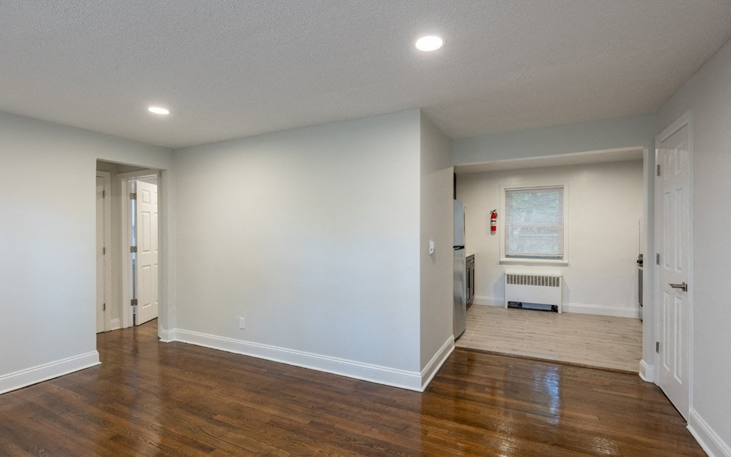 a living room with a hard wood floor and white walls